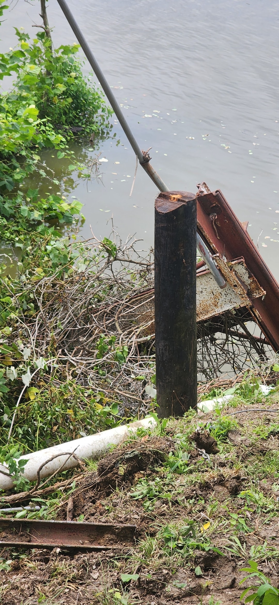 Waterside fence post and rusted metal structure removal near Texas waterway
